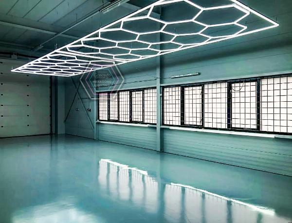 What measures do car detailers take to minimize shadows and glare in their workshop?